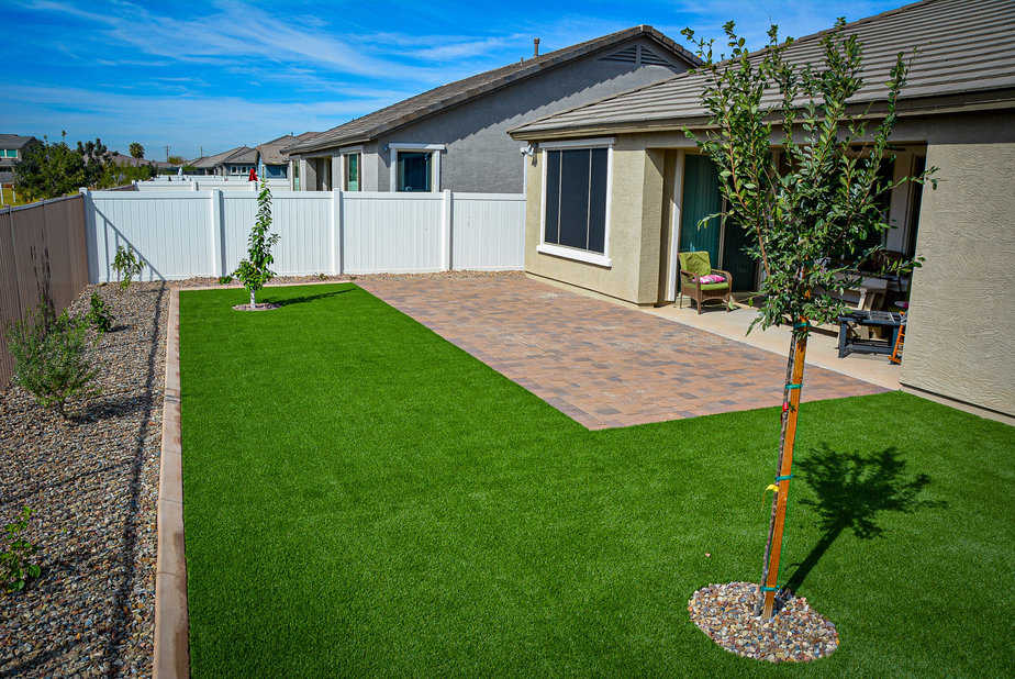 Artificial grass masters installed a paver pad, synthetic grass, trees, concrete curbing_