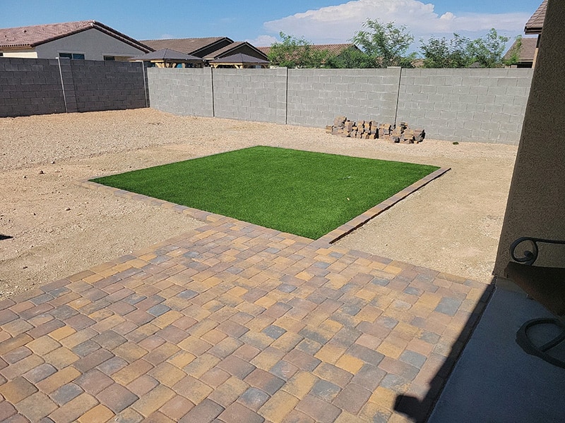 pillow top paver patio with square patch of artificial turf